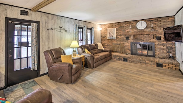 A living room with a fireplace, leather sofas, and a clock on the wall. - Illinois Vacation Rental Home: Pets Welcome (Palestine)
