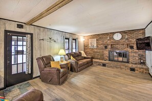 A living room with a fireplace, leather sofas, and a clock on the wall. - Illinois Vacation Rental Home: Pets Welcome (Palestine)