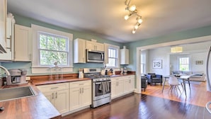 A modern kitchen with white cabinets, a stainless steel stove, and a large window. - Birmingham Vacation Rental: 9 Miles to Downtown! (Birmingham)