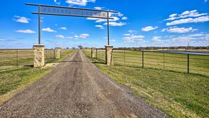 A gravel road leading to a sign that reads "FLYING C RANCH."