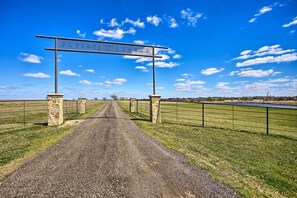 A gravel road leading to a sign that reads "FLYING C RANCH."