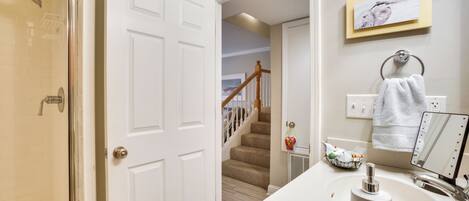 A bathroom with a white sink, a mirror, and a towel rack.