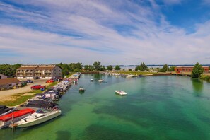 A marina with boats docked, a clear sky, and buildings in the background. - Lakefront Elk Rapids Vacation Rental w/ Deck! (Elk Rapids)