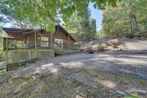 Una cabaña con un porche, terraza de madera y un sendero de piedra que conduce a la entrada.