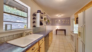 Cocina con ventana grande, pileta, cocina y alacenas.