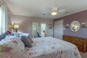 A bedroom with a bed, a dresser, a chair, a ceiling fan, and a door with blinds. - Pool & Amazing View: Updated Grand Lake Getaway (Grove)