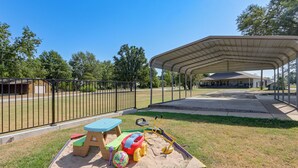 A covered outdoor play area with sand, a table, and toys. - Pool & Amazing View: Updated Grand Lake Getaway (Grove)