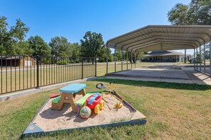 A covered outdoor play area with sand, a table, and toys. - Pool & Amazing View: Updated Grand Lake Getaway (Grove)