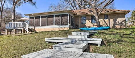 A house with a screened porch, a swimming pool, and a deck with benches.