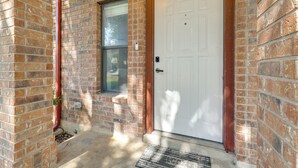 A brick exterior with a white door, a window, and a welcome mat. - New Braunfels Escape, Walk to Gruene Hall! (New Braunfels)