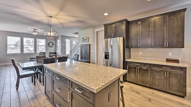 A modern kitchen with granite countertops, dark cabinetry, and stainless steel appliances. - Spacious Flagstaff Home w/ Fenced Yard & Grill! (Flagstaff)