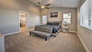 A bedroom with a bed, a ceiling fan, a nightstand, and a window with blinds. - Spacious Flagstaff Home w/ Fenced Yard & Grill! (Flagstaff)