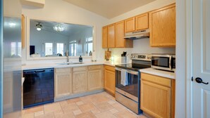 A modern kitchen with wooden cabinets, a dishwasher, an oven, and a microwave. - 3 Mi to Surprise Stadium! Retreat w/ Putting Green (Surprise)