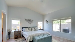 A bedroom with a bed, bedside tables, a bench, and a window. - 3 Mi to Surprise Stadium! Retreat w/ Putting Green (Surprise)