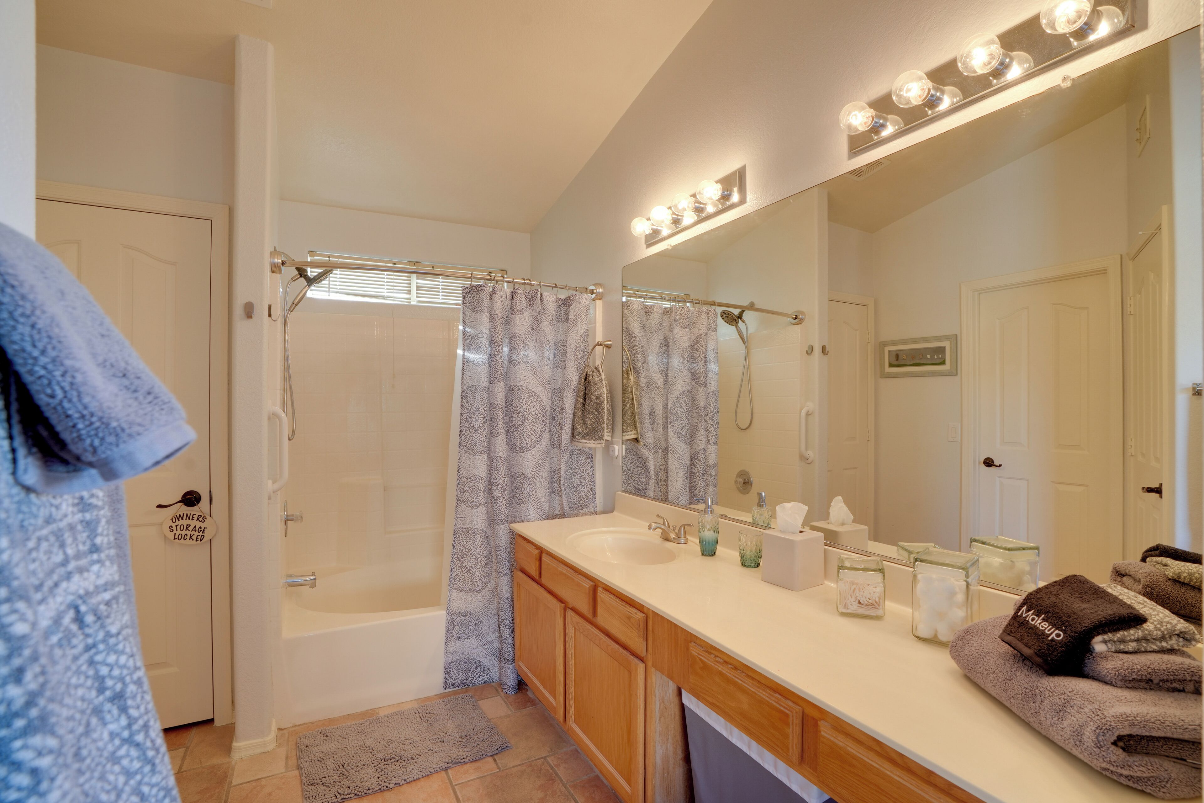 A bathroom with a bathtub, a shower, a vanity with a mirror, and towels.
