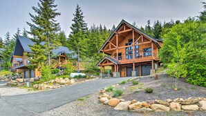 Eine Lodge mit markantem Holzbau, einem Steinweg und umgebendem Wald.