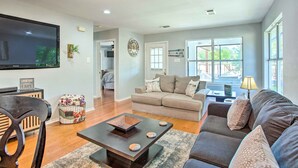 A spacious living room with a large flat-screen TV, a sofa, a coffee table, and a dining area. - Lakefront Family Home w/ Boat Dock + Slip in Texas (Trinidad)