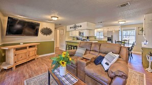 A spacious living room with a brown leather couch, a wooden entertainment unit, and a flat-screen TV. - 'whispering Oaks' Broken Bow Cottage Near Hiking! (Broken Bow)