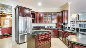 A spacious kitchen with dark wooden cabinets, stainless steel appliances, and a large island.