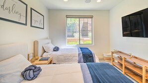 A hotel room with two beds, a large window, a flat-screen TV, and a wooden bench. - Scottsdale Condo w/ Resort-style Perks! (Scottsdale)