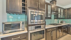 A modern kitchen with stainless steel appliances, dark wood cabinets, and a light-colored countertop. - Scottsdale Condo w/ Resort-style Perks! (Scottsdale)