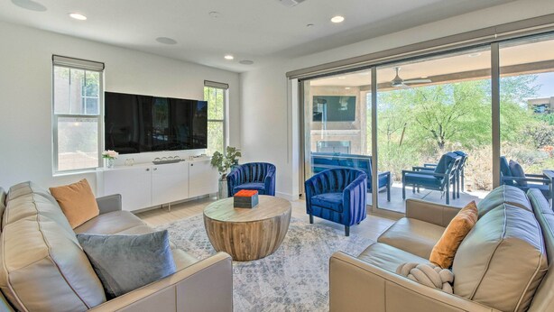 A modern living room with a large TV, comfortable seating, and a view of the outdoors. - Scottsdale Condo w/ Resort-style Perks! (Scottsdale)