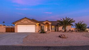 A single-story house with a garage, a driveway, and a gravel driveway.