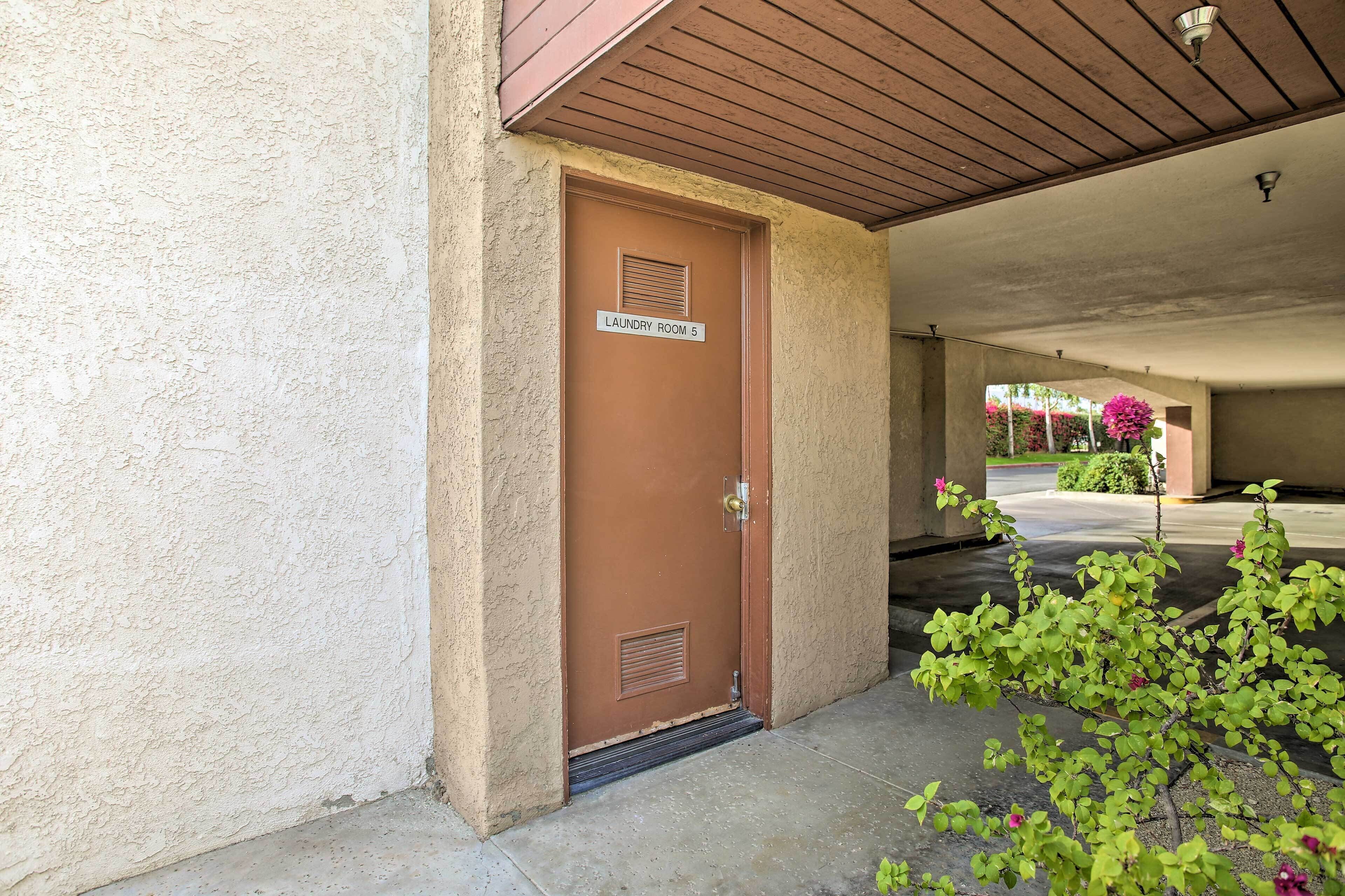 A brown door with a sign reading "Laundry Room 5" and a small step leading to a covered entrance.