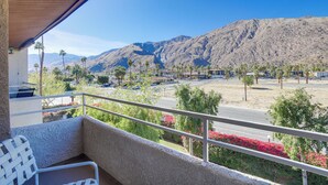 A balcony with a view of mountains, a road, and some greenery. - Walk to Dtwn Palm Springs: Condo w/ Pool Access (Palm Springs)