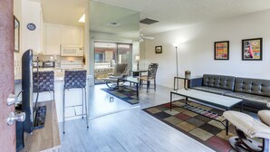 A modern kitchen with white cabinets, a microwave, and a dining area with a table and chairs. - Walk to Dtwn Palm Springs: Condo w/ Pool Access (Palm Springs)
