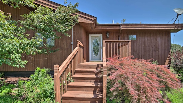 A wooden house with a wooden staircase leading to a front door, surrounded by greenery and a satellite dish. - Grand Escape w/ Deck, Game Room, Nature View! (Brooklyn)