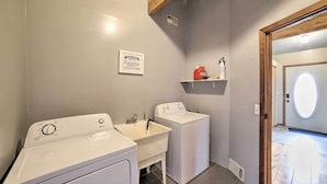 A laundry area with two washing machines and a sink. - Grand Escape w/ Deck, Game Room, Nature View! (Brooklyn)