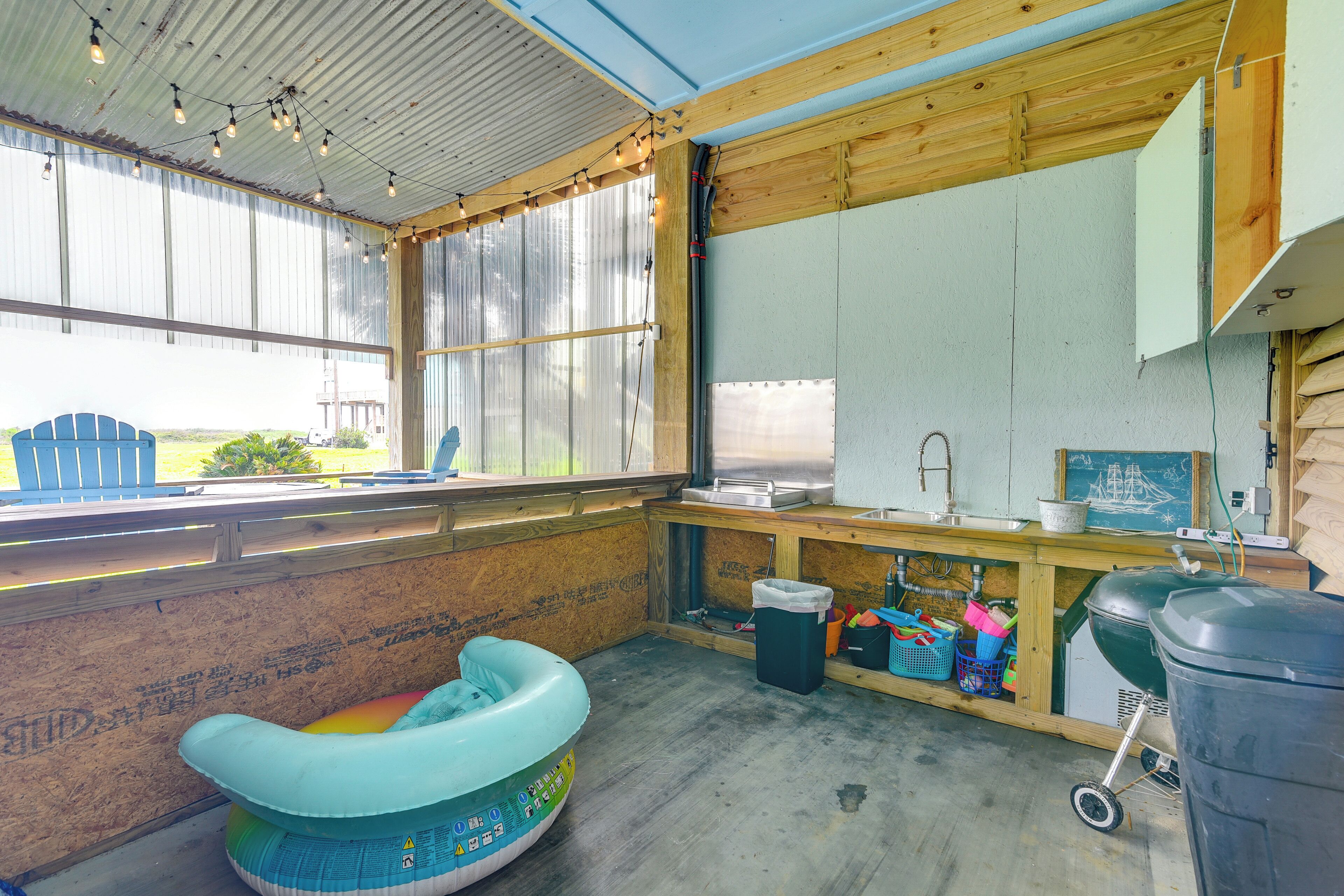 A kitchen with wooden cabinets, a window, and a blue inflatable chair.