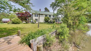 A house with a green roof, surrounded by a grassy yard and a wooden deck. - 15 Mi to Gloucester: Waterfront Mathews Home! (Mathews)