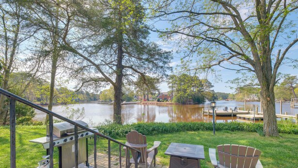 A patio with a grill, chairs, and a table overlooking a lake. - 15 Mi to Gloucester: Waterfront Mathews Home! (Mathews)