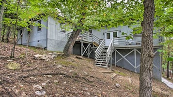 Escape to a secluded cabin surrounded by nature, with a staircase leading to a cozy upper level.