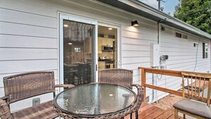 A covered outdoor patio with wicker chairs and a glass table, a sliding glass door leading to a kitchen, and a wooden deck railing. - 1 Mi to Winery: Clifton Escape w/ Grill & Yard! (Clifton)