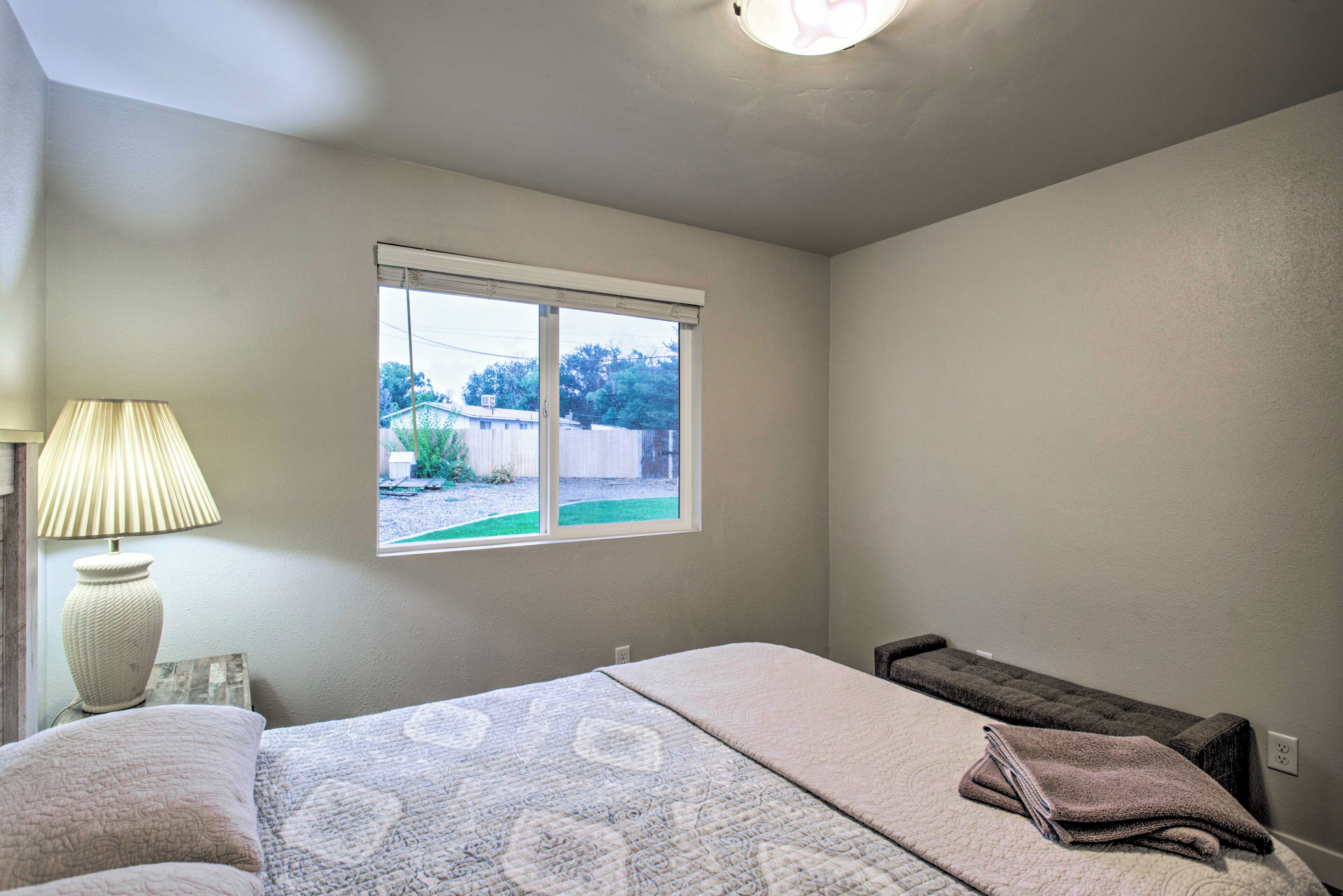 A bedroom with a bed, a window, and a lamp.