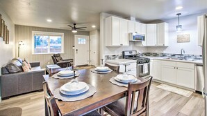A modern kitchen with white cabinets, a dining table set with plates, and a built-in oven. - 1 Mi to Winery: Clifton Escape w/ Grill & Yard! (Clifton)