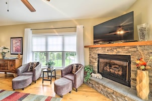 Una sala de estar con chimenea, un televisor de pantalla plana y dos sillones.