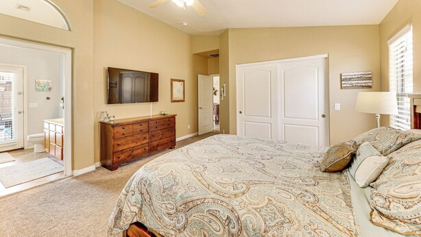 A bedroom with a bed, a ceiling fan, a dresser, a television, and a door. - Sunny Maricopa Getaway w/ Private Pool + Fire Pit! (Maricopa)