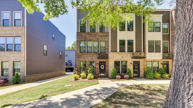 A multi-story residential building with a brick facade, large windows, and a well-maintained lawn. - Updated Charlotte Vacation Rental 4 Mi to Downtown (Charlotte)