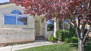 A single-story house with a front door, a large window, and a small front yard with a tree and shrubs. - Home w/ Game Room & Fire Pit: 30 Min to Zion! (La Verkin)