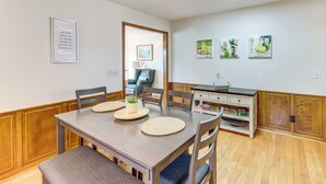 A dining area with a wooden table, chairs, and a bench. There are placemats on the table, and a framed quote on the wall. - Beautiful Lakefront Home With Plenty of Space! (Jacksons' Gap)