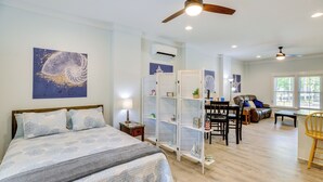Ein Schlafzimmer mit einem Bett, einem Deckenventilator und einem Nachttisch.