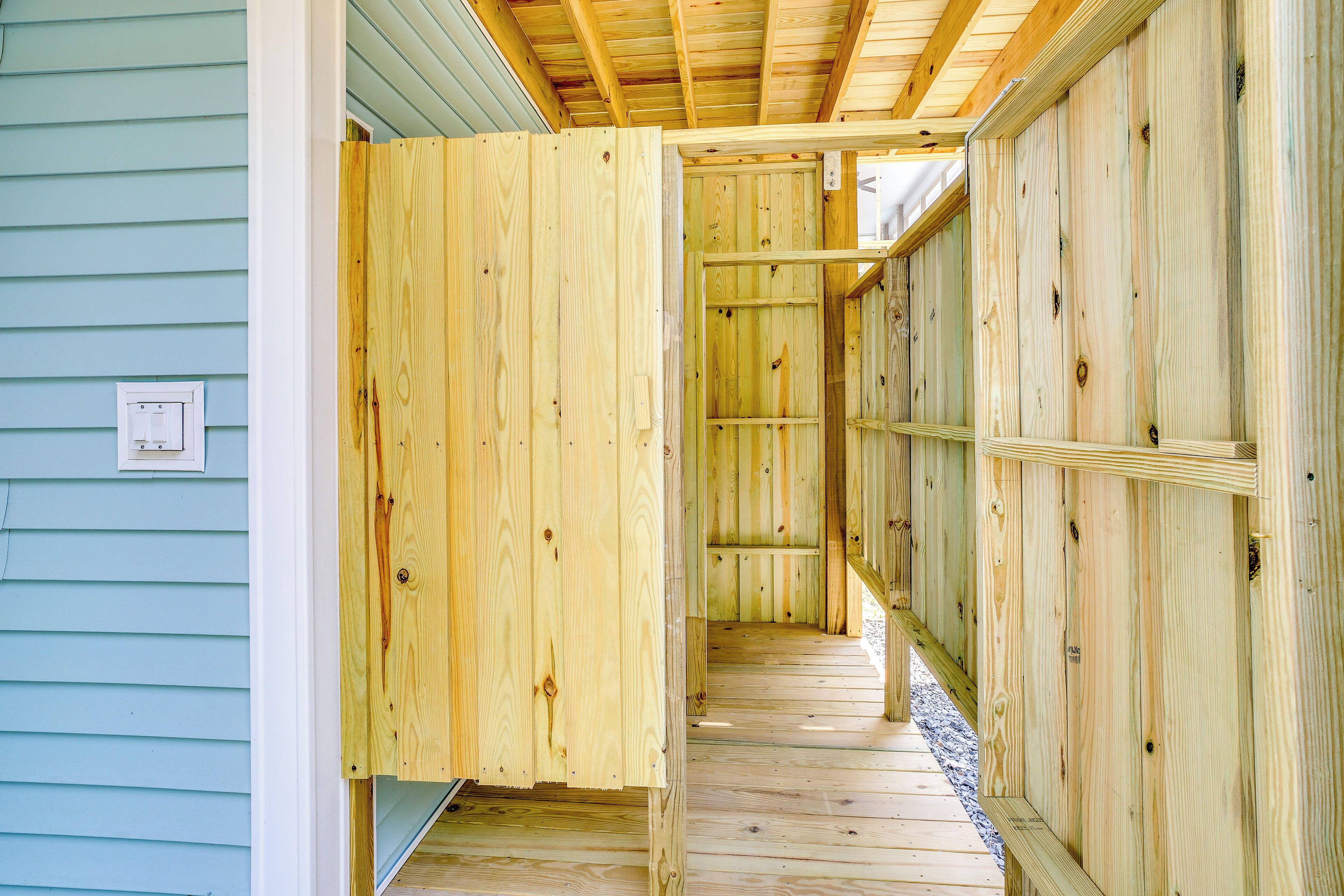 Un pasillo interior de madera con una puerta y un ventanal.