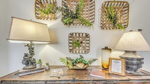 A wooden desk with a lamp, a framed picture, and decorative baskets with plants. - Charming Ruidoso House w/ Deck & Mountain Views! (Ruidoso)