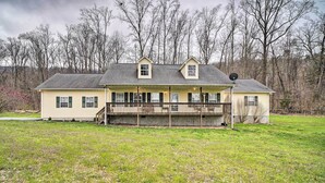 A two-story house with a covered porch, a satellite dish, and a large yard. - Charming 'hideaway Haven' Near Pigeon Forge! (Dandridge)