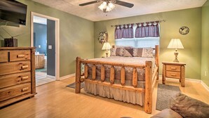A bedroom with a wooden bed, a ceiling fan, a TV, and a window with curtains. - Charming 'hideaway Haven' Near Pigeon Forge! (Dandridge)