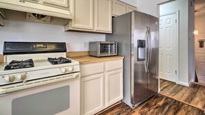 A kitchen with white cabinets, a stainless steel refrigerator, a gas stove, and a toaster oven. - Maryland Vacation Home Near US Capital! (Riverdale)